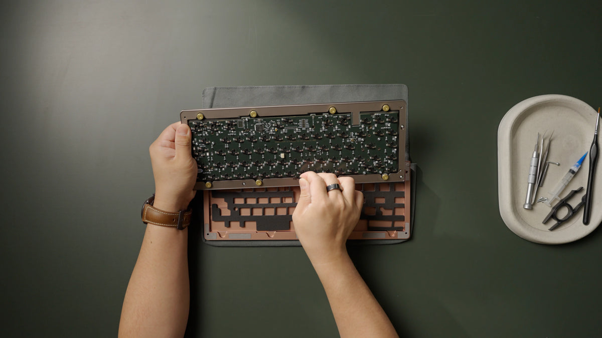 Hold the top case in one hand while connecting the daughterboard cable with the other.